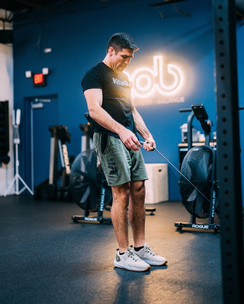 A MOB Boca member training under the glowing neon mob sign