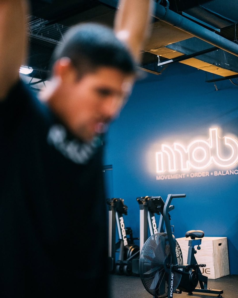 Inside the MOB Boca training floor, lit by the neon mob sign